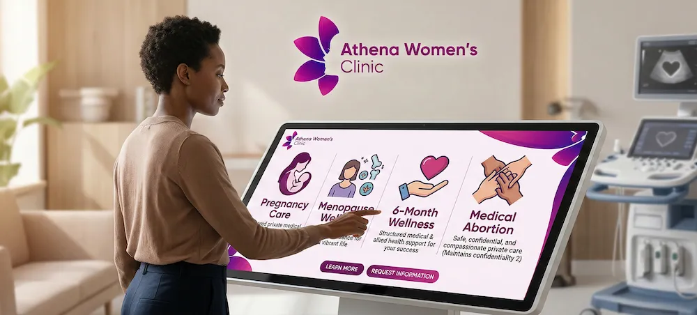 A woman in a modern clinic setting interacting with a large digital touch screen that displays Athena Women's Clinic's four primary healthcare packages: Pregnancy Care, Menopause Wellness, 6-Month Wellness, and Medical Abortion.